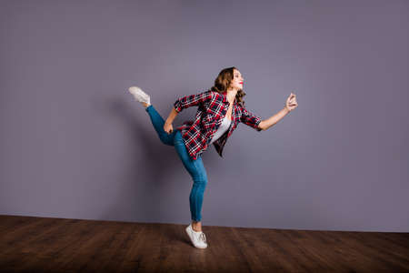 Full length size body view photo fly high amazing attractive beautiful she her lady modern training zumba flexible stand on one leg wearing casual jeans denim checkered plaid shirt on grey backgroundの写真素材