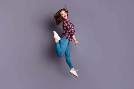 Full length size body view photo jumping high amazing attractive she her lady flight in air coquettish behaviour wearing casual jeans denim checkered plaid shirt grey backgroundの写真素材