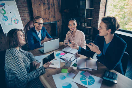 Four nice chic stylish elegant cheerful staff business sharks experts researching report profit growth plan economy charts data appointment at industrial loft interior work place stationの写真素材