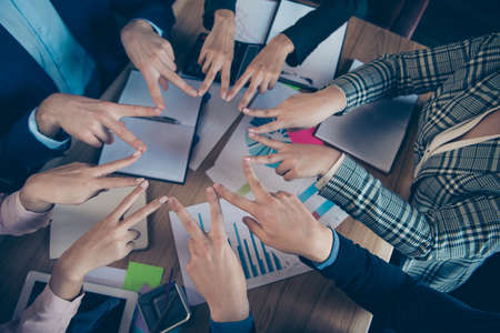 Top above high angle cropped close-up view of stylish staff putting v-sign in round circle over desktop desk table charts diagram graph graphic data analysis result at work place stationの写真素材