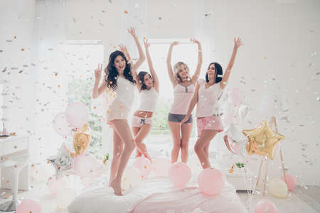 Full length body size portrait of nice-looking attractive lovely fascinating girlish feminine charming fit slim cheerful cheery girlfriends sisters having fun in light white interior decorated houseの写真素材