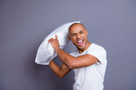 Close up photo strong healthy dark skin he him his macho bald head yell hold pillow ready for battle play playful like child wearing white t-shirt outfit clothes isolated grey backgroundの写真素材