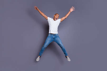 Full length body size portrait of his he nice handsome attractive masculine virile guy wearing white shirt jeans having fun isolated over gray violet purple pastel backgroundの写真素材
