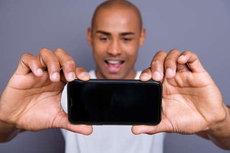 Close up photo attractive dark skin he him his macho short hairdo make take selfies on main telephone camera yeah yes facial expression wearing white t-shirt outfit clothes isolated grey backgroundの写真素材