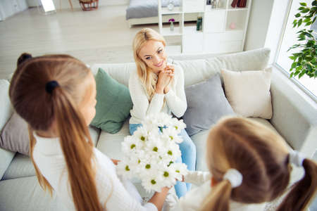High above angle view of nice lovely attractive charming cheerful positive mom sitting on divan...