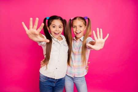 Close up photo two small little age she her girls hands arms palms counting fingers school lesson class wearing casual jeans denim checkered plaid shirts isolated rose vibrant vivid backgroundの写真素材