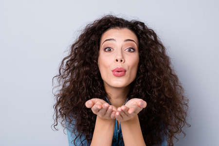 Close-up portrait of her she nice cute pretty winsome lovable fascinating charming attractive lovely cheerful wavy-haired girl sending kiss isolated over gray pastel backgroundの写真素材