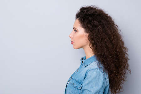 Close-up profile side view portrait of her she nice-looking cute well-groomed charming attractive candid wavy-haired girl isolated over gray pastel backgroundの写真素材