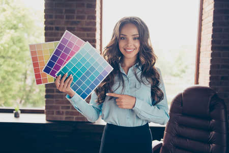 Close up photo beautiful she her business lady hold pallet different colors show pick shade tone approving good result quality stand office comfort chair wearing formal-wear suitの写真素材