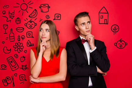 Portrait of his he her she two lovely attractive elegant chic people dress and bow tux looking aside up planning weekend new life development isolated over bright vivid shine red backgroundの写真素材