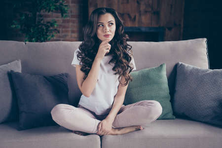 Close up portrait amazing beautiful brunette she her lady legs couch arm chin pillows think over dinner menu evening family wearing home domestic white sweatpants t-shirt outfit sit comfy divanの写真素材