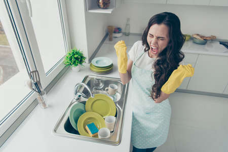 Above high angle view of her she attractive beautiful irritated annoyed fury frustrated devastated wavy-haired house-wife showing rage gesture near dirty plates pile in modern light white interiorの写真素材