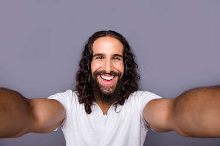 Self-portrait of nice cool well-groomed attractive cheerful cheery glad ecstatic optimistic wavy-haired guy lifestyle isolated over gray violet purple pastel background.の写真素材