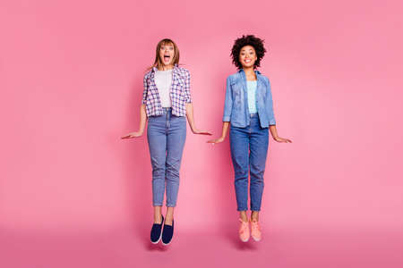 Full length body size view portrait two funky diversity she her ladies jumping high playful childish...