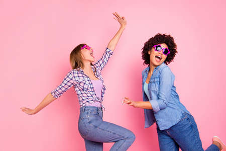 Portrait of two person nice cool crazy careless carefree attractive charming cheerful cheery childish playful girls wearing casual checkered shirt having fun isolated over pink pastel backgroundの写真素材