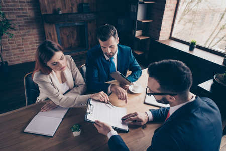 Above high angle view portrait of three nice elegant stylish trendy beautiful handsome serious minded busy executive top sales managers contract sign in loft industrial interior work place station.の写真素材