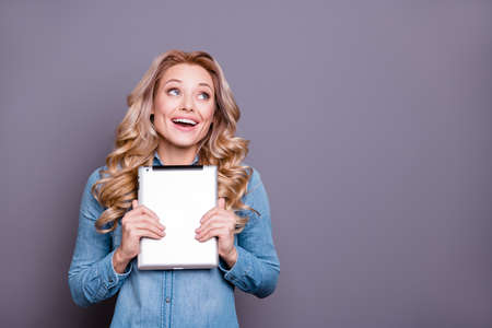 Portrait of her she nice cute lovely sweet fascinating charming attractive cheerful wavy-haired lady wearing blue shirt holding in hands tablet fantasize fancy isolated over gray pastel backgroundの写真素材