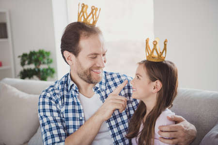 Close-up portrait of his he her she nice cute sweet tender attractive cheerful positive pre-teen girl bearded dad daddy sitting on divan touching nose cuddling in light white interior room indoorsの写真素材