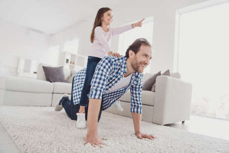 Portrait of his he her she nice cute lovely attractive pre-teen cheerful cheery dreamy girl handsome bearded dad daddy having fun pointing far away dream in light white interior room indoorsの写真素材