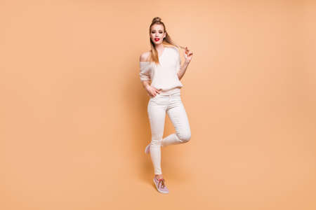 Full length body size view portrait of her she nice lovely attractive fascinating adorable straight-haired girl wearing white sweater touching curls isolated over beige pastel backgroundの写真素材