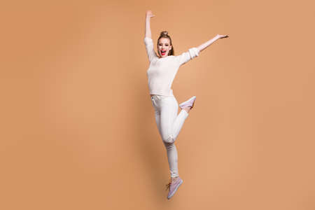 Full length body size view portrait of her she nice graceful feminine attractive adorable straight-haired cheerful girl wearing white sweater raising hands up isolated over beige pastel backgroundの写真素材