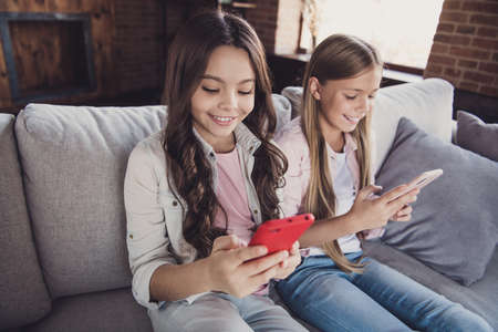 Portrait of two nice cute sweet lovely attractive charming cheerful cheery confident girls sitting...