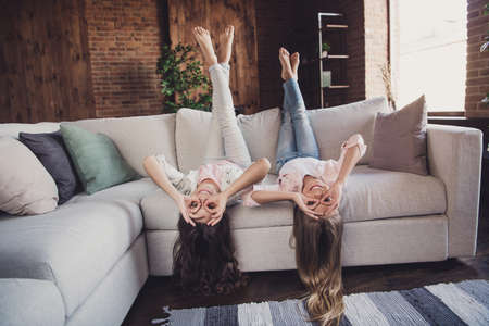 Two nice lovely attractive healthy cheerful cheery friendly optimistic girls lying on divan...