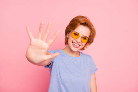 Portrait of her she nice cute charming attractive lovely winsome cheerful cheery girl wearing casual blue t-shirt yellow glasses giving you high five isolated over pink background.の写真素材