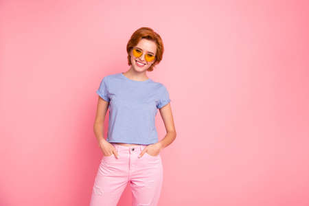 Portrait of her she nice cute charming attractive lovely cheerful cheery girl wearing casual look cool yellow glasses holding hands in pockets isolated over pink pastel backgroundの写真素材