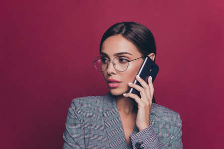 Close-up portrait of her she nice cute attractive lovely sweet winsome delicate gorgeous magnificent lady wearing gray checkered jacket talking on line isolated over maroon burgundy marsala backgroundの写真素材