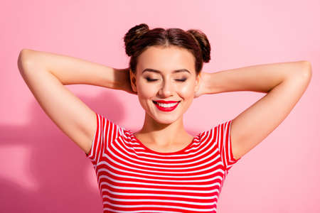 Close up photo beautiful she her lady pretty buns eyes closed dreamer having nap arms hands behind head weekend day off making wish wear casual striped red white t-shirt isolated pink backgroundの写真素材