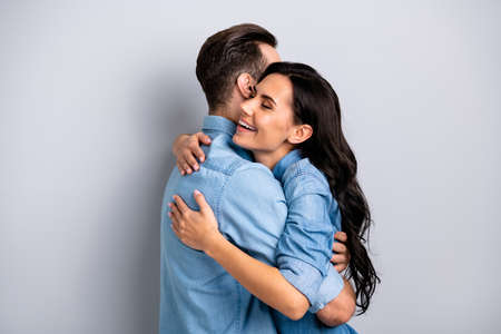 Sweetheart dear profile side photo handsome casual fashionable modern guy girl are meeting getting warm hugs closing eyes isolated on grey background in blue clothingの写真素材