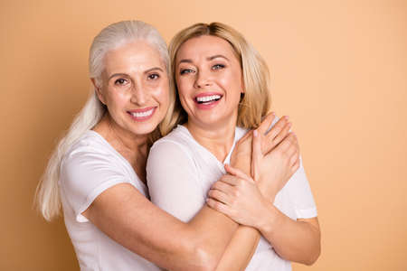 Close-up portrait of nice-looking attractive cute charming sweet tender adorable lovely cheerful cheery ladies having fun free time enjoying isolated over beige pastel backgroundの写真素材