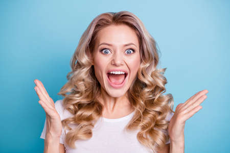 Close up photo beautiful yelling amazing her she lady fan goal lucky facial expression hands arms palms raised up wearing casual white t-shirt clothes outfit isolated bright blue backgroundの写真素材