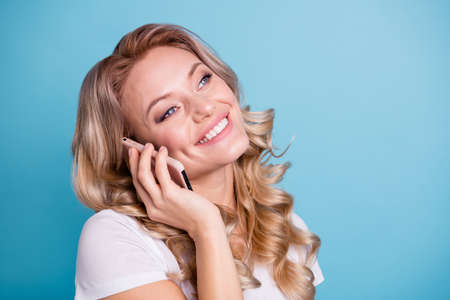 Close-up portrait of her she nice-looking fascinating lovely sweet winsome attractive cheerful wavy-haired lady enjoying talking to boyfriend isolated over blue pastel backgroundの写真素材