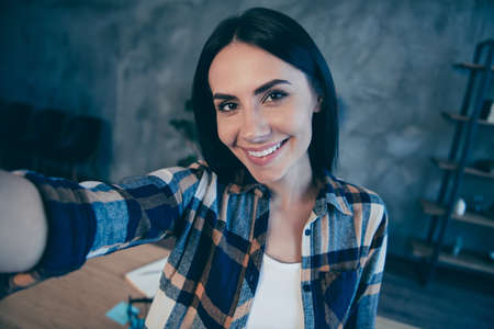 Self-portrait of her she nice cute lovely attractive charming sweet cheerful brunette lady wearing checked shirt rest relax free time at industrial loft style interior work place stationの写真素材