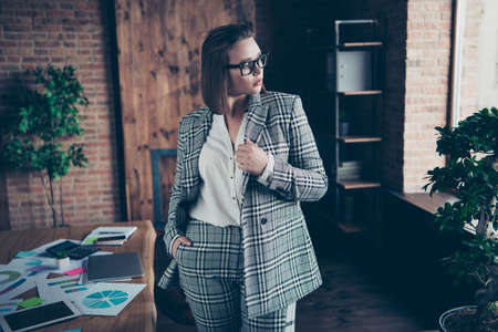 Close up photo beautiful amazing she her business busy lady hands arms pockets turned off notebook table look side deep thinking minded stand front office specs formal-wear checkered plaid suitの写真素材