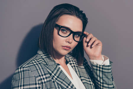 Closeup photo of beautiful serious attractive pretty with ideal perfect makeup bob dark brown haircut touching adjusting black specs wearing white collar suit isolated grey backgroundの写真素材