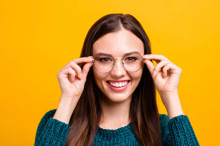 Close-up portrait of her she nice attractive clever smart intelligent cheerful straight-haired girl touching glasses isolated over bright vivid shine yellow backgroundの写真素材