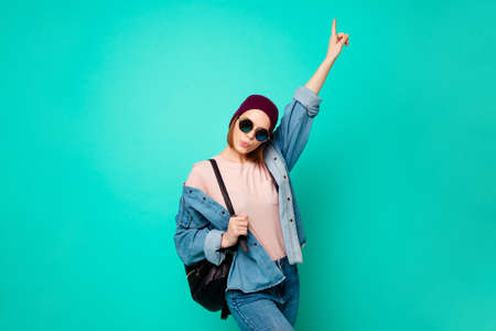 Close up photo beautiful her she lady modern look indicate finger up empty space advising buy buyer new product wear specs hat casual jeans denim t-shirt clothes isolated teal turquoise backgroundの写真素材