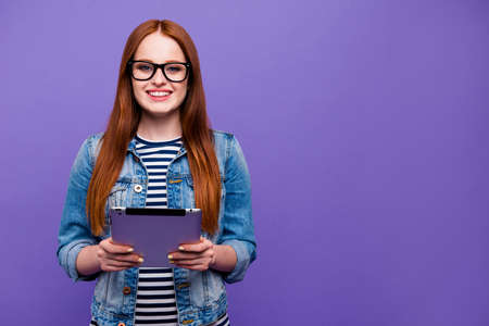 Portrait of her she nice-looking attractive charming cute winsome lovely cheerful cheery straight-haired lady holding in hands new device isolated over bright vivid shine violet backgroundの写真素材