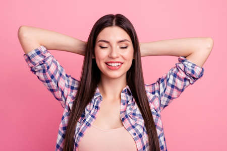 Close up photo amazing beautiful her she lady peaceful hold hands arms behind head eyes closed white teeth toothy smile wear casual checkered plaid shirt clothes outfit isolated pink backgroundの写真素材