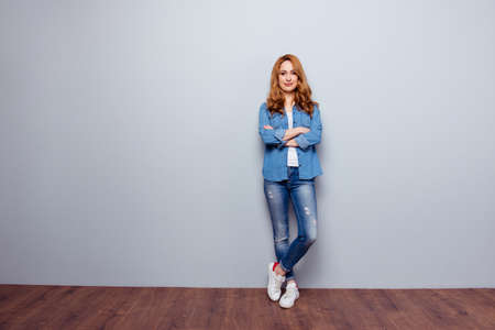 confident woman wearing casual blue jeans denim shirt isolated grey backgroundの写真素材