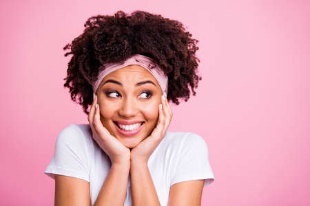 Close up photo beautiful amazing she her dark skin lady hold hands arms palms cheeks cheekbones cute peaceful look side empty space wear head scarf casual white t-shirt isolated pink bright backgroundの写真素材