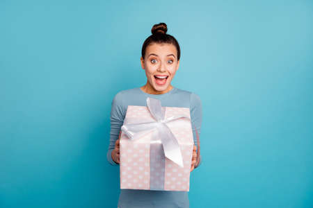 Portrait of astonished millennial get incredible gift for 14-february 8-march impressed wonder holiday dressed modern clothes white trousers isolated on blue background positive cheerful contentの写真素材