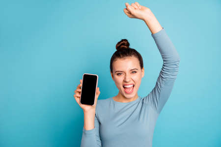 Close-up portrait of her she nice-looking attractive cute winsome lovely cheerful cheery ecstatic girl holding in hand new cool purchase isolated over bright vivid shine turquoise backgroundの写真素材