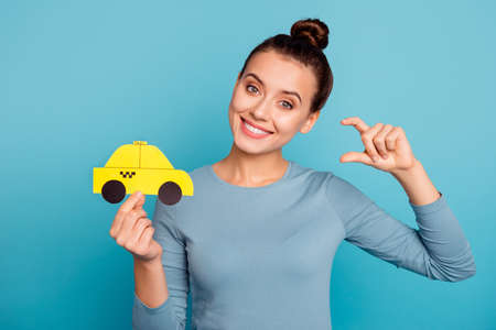 Portrait joy excited cheerful beautiful positive lady hipster hold hand yellow show advantage offer go call order uber stylish style trendy shirt beautiful hair hairstyle isolated blue backgroundの写真素材