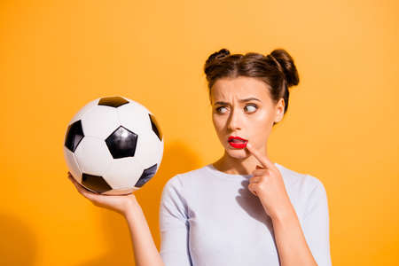 Close up photo beautiful hairdo she her lady judge referee hold raise hand arm leather ball finger chin mouth hate football afraid to be injured wear casual white pullover isolated yellow backgroundの写真素材
