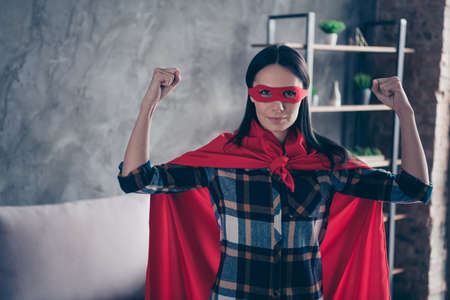 Close up photo beautiful funky she her superpower lady dynamic comics costume women equal rights concept strong hands arms wear red eye mask mantle home living room loft apartment flat indoorsの写真素材