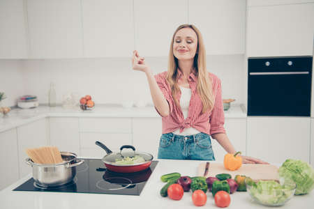 Close up photo beautiful she her lady fingers belissimo okey symbol check quality advising meal dish expert yummy wear domestic home apparel shirt jeans denim outfit bright home kitchen indoorsの写真素材